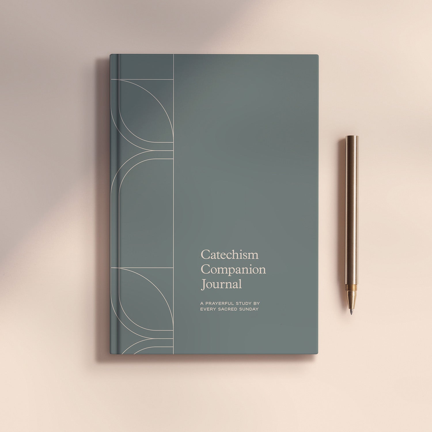 Catechism Companion Journal next to metal pen on light brown background
