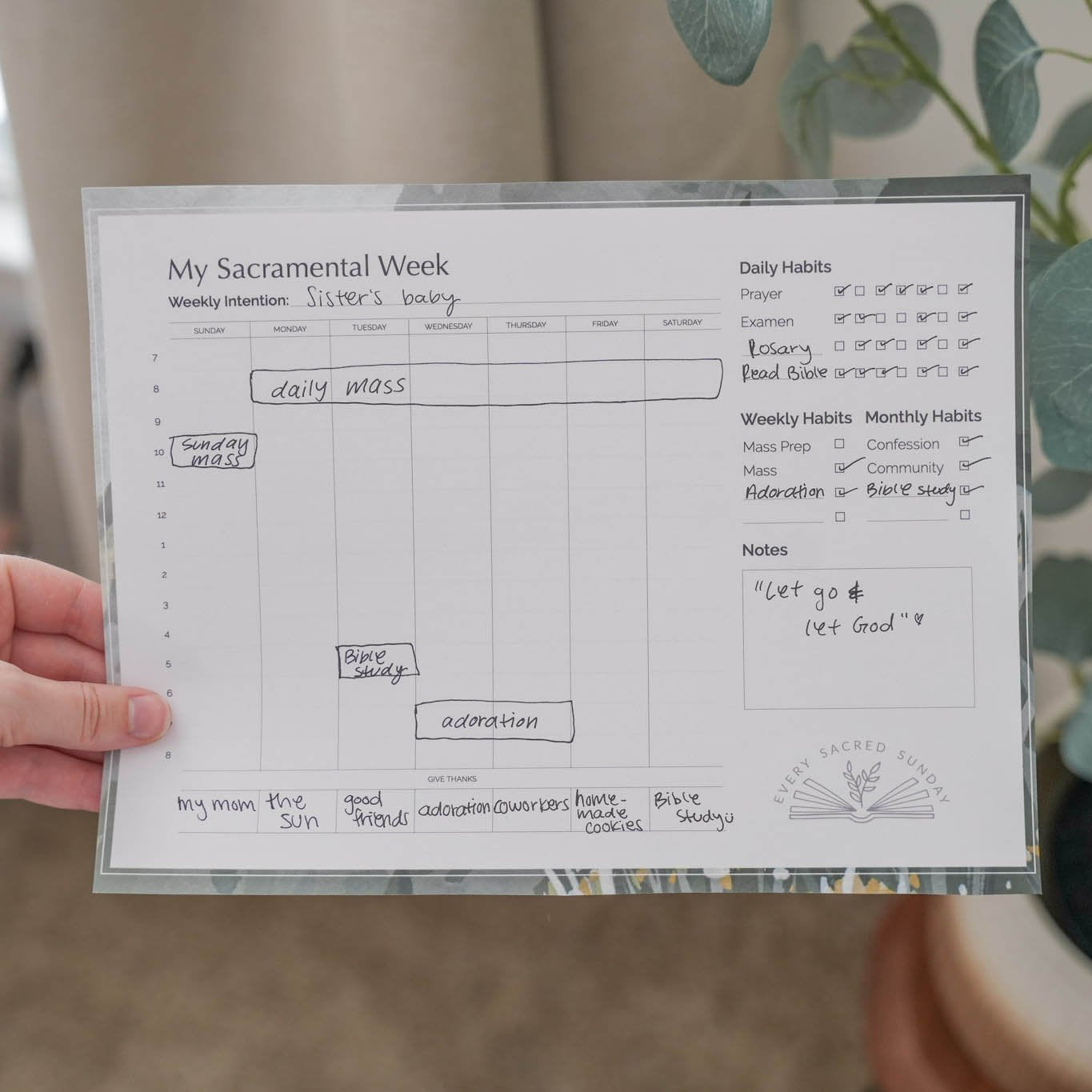 person holding filled out sacramental calendar