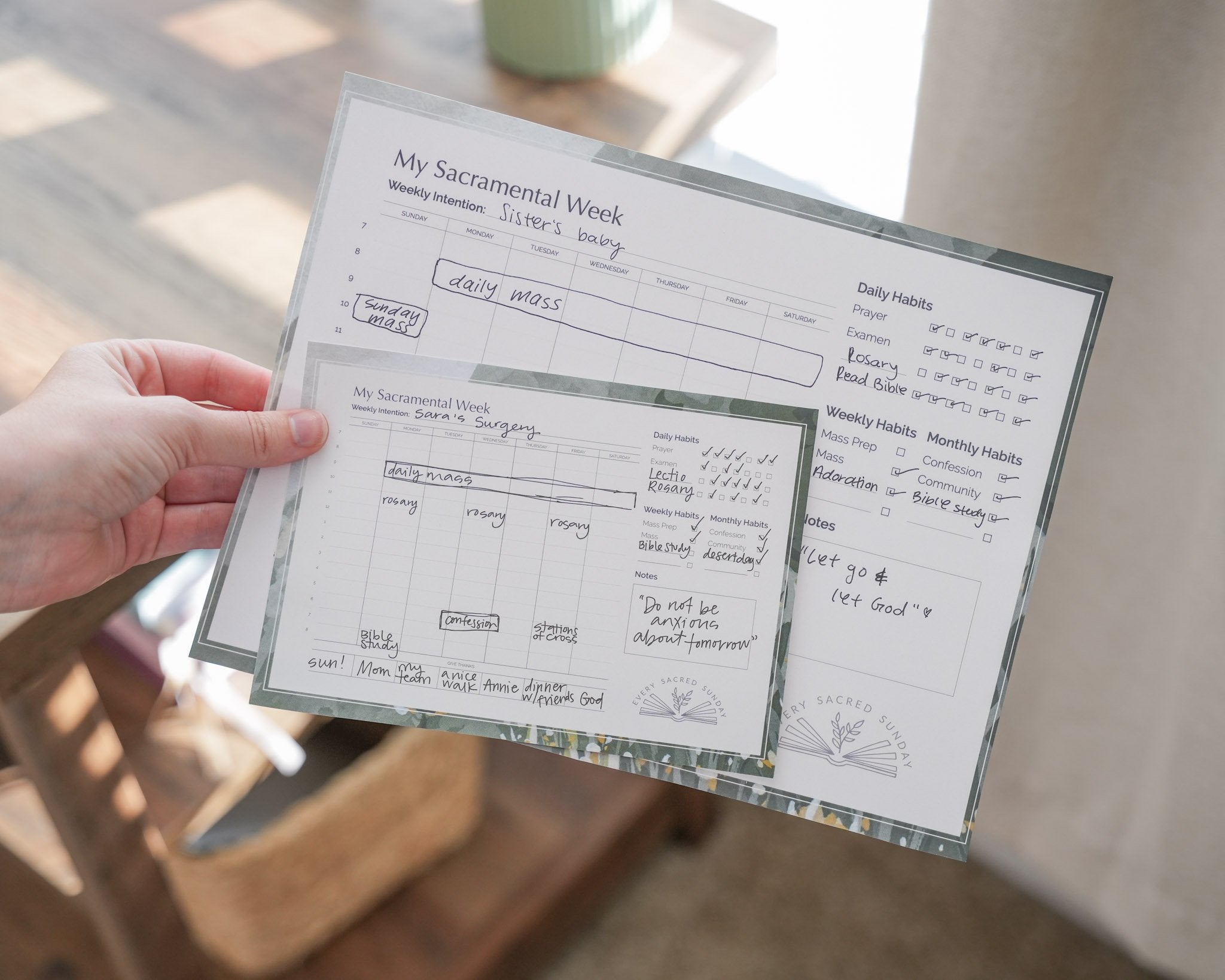 person holding large and small versions of my sacramental week calendar