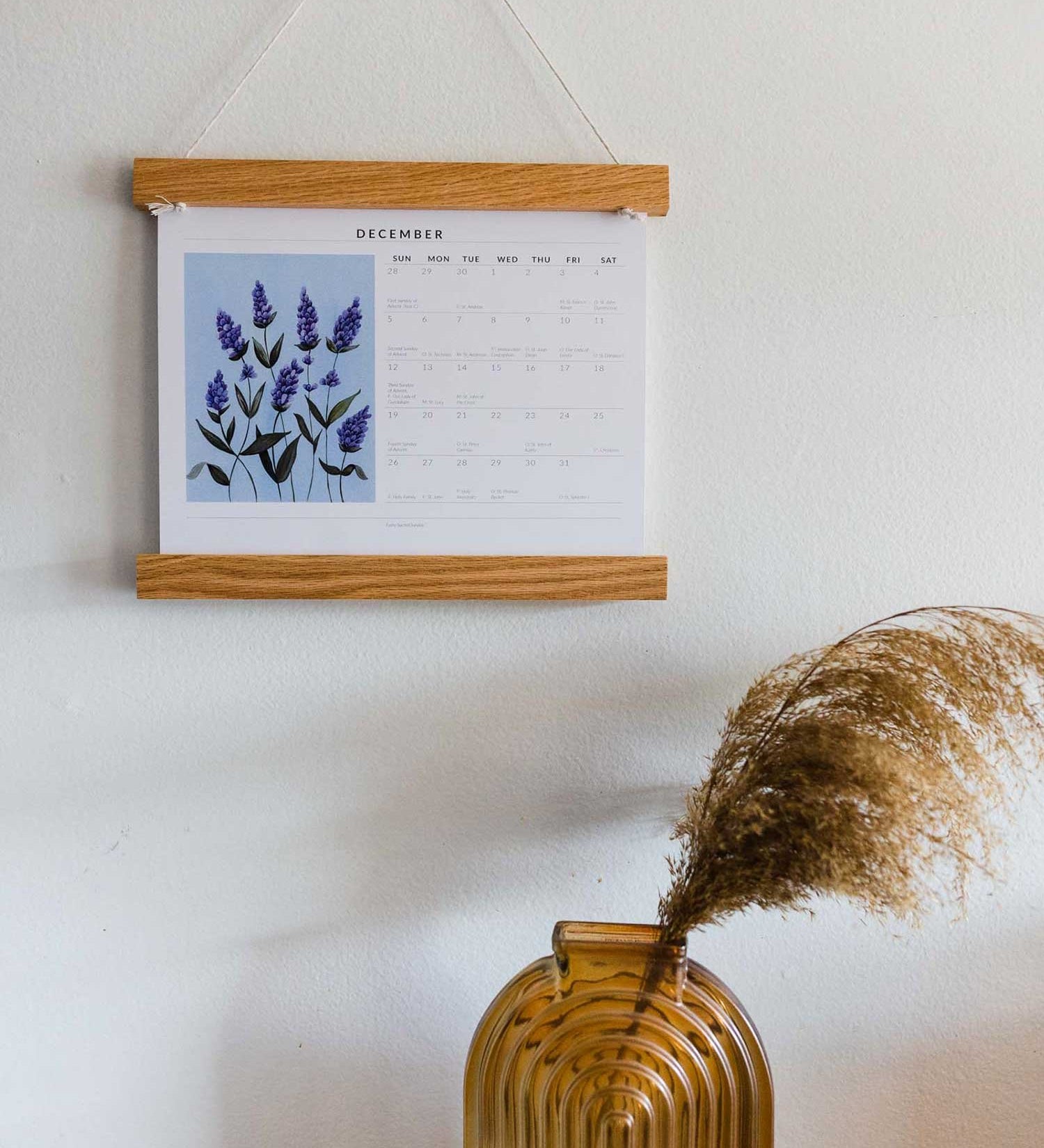 zoomed out photo of liturgical calendar next to brown glass vase and candle 