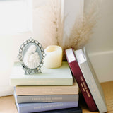 mass journals in stack next to window with candle and mother's kiss cameo